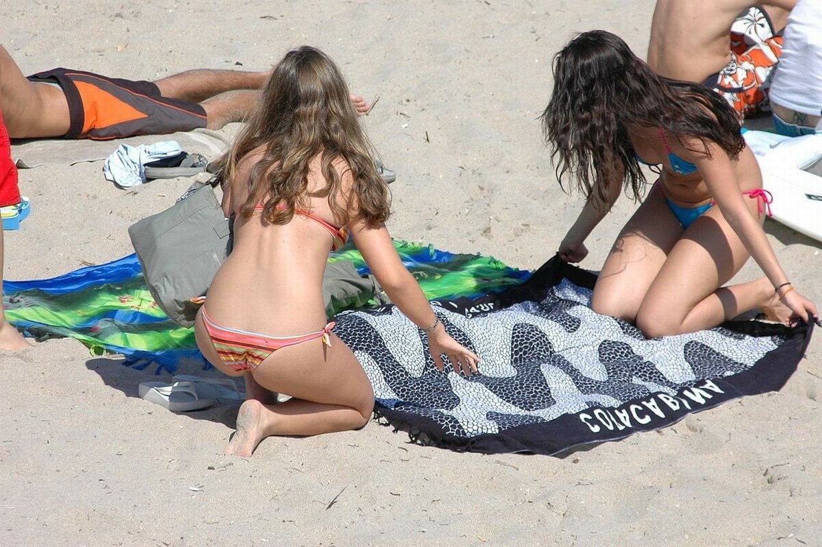 Девушка загорает топлес на пляж